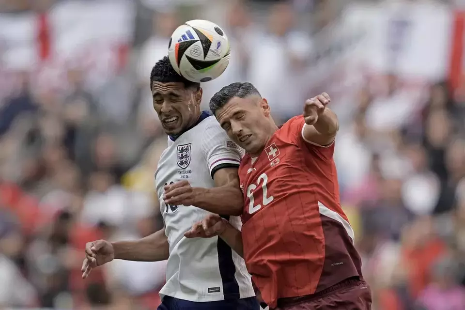 Pemain Inggris Jude Bellingham (kiri) berebut bola dengan pemain Swiss Fabian Schar pada perempat final Euro 2024 di Duesseldorf, Jerman, Sabtu, 6 Juli 2024.